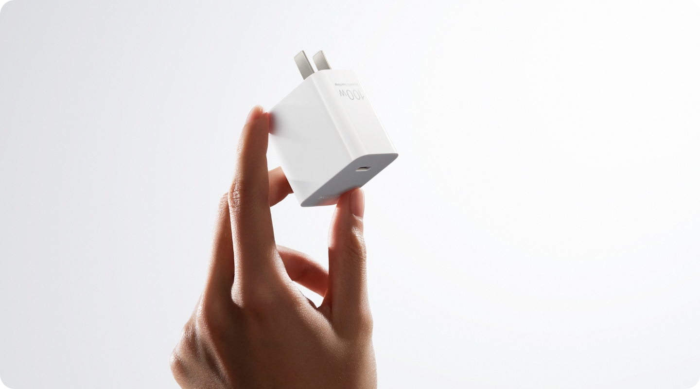 用户从小包中拿出华为冰糖全能充电器(Max 100 W),展示了充电器的小巧轻盈