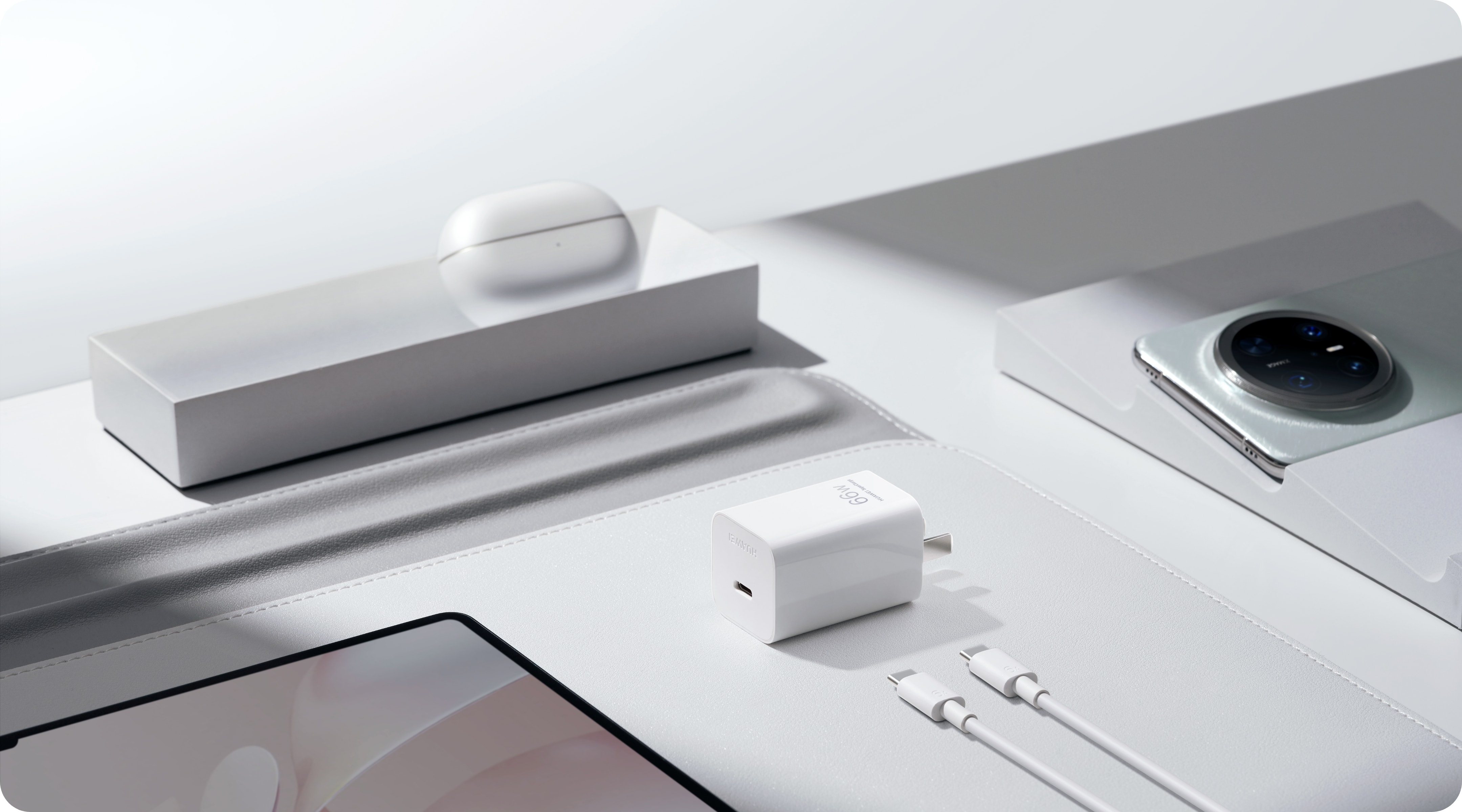 华为冰糖全能充电器 (Max 66W) 置于桌面上,旁边有耳机、充电器、平板及数据线,展示了充电器的兼容性