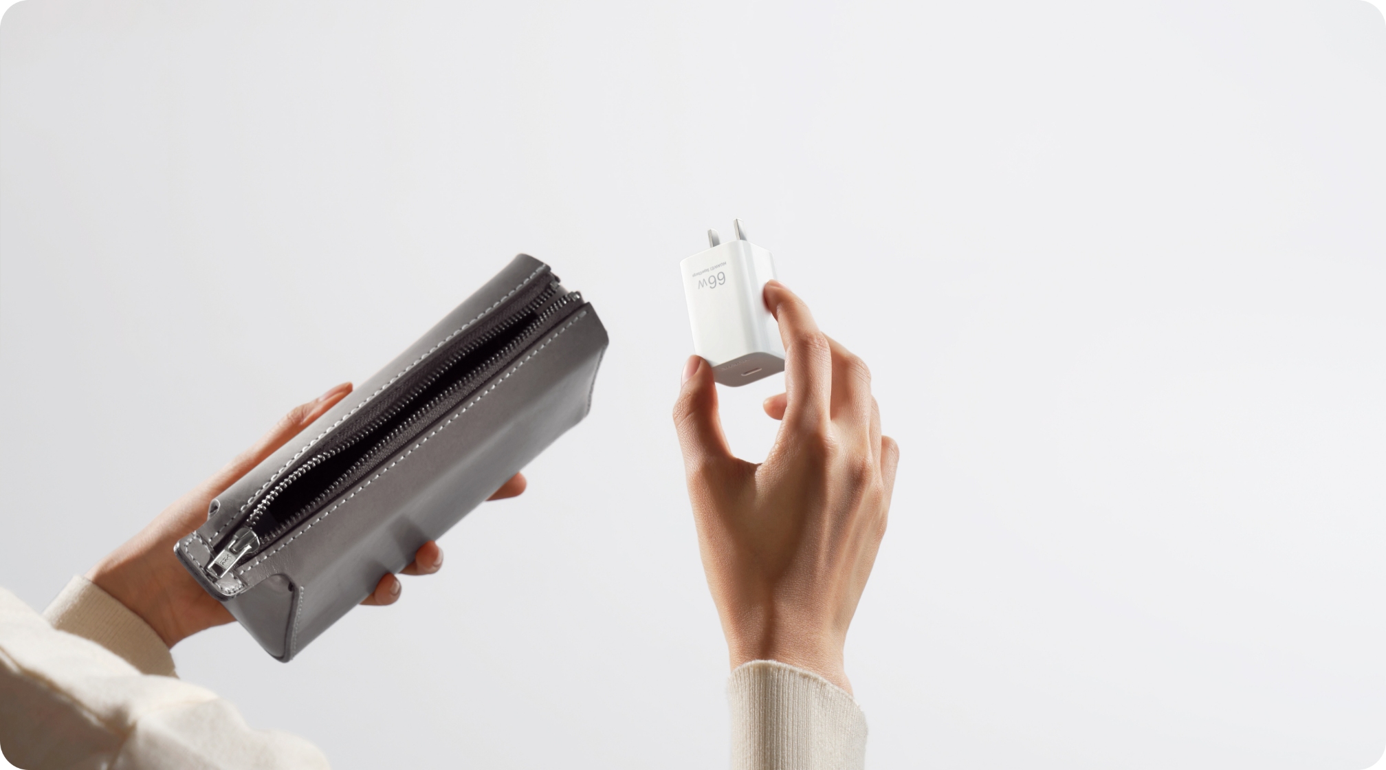 用户从小包中拿出华为冰糖全能充电器 (Max 66W),展示了充电器的小巧轻盈