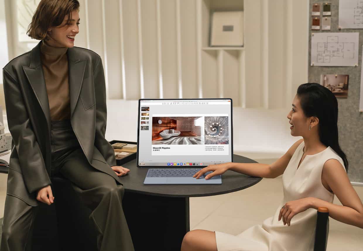 两个女人围绕着横屏的 HUAWEI MateBook Fold 非凡大师观看演示文档，并使用华为星跃随行键盘编辑文档