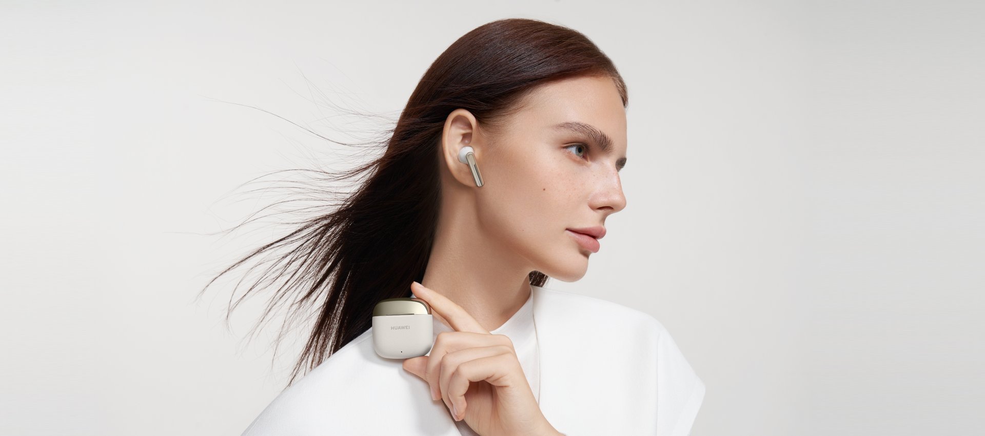 一位女生戴 HUAWEI FreeBuds SE 3,手拿耳机盒