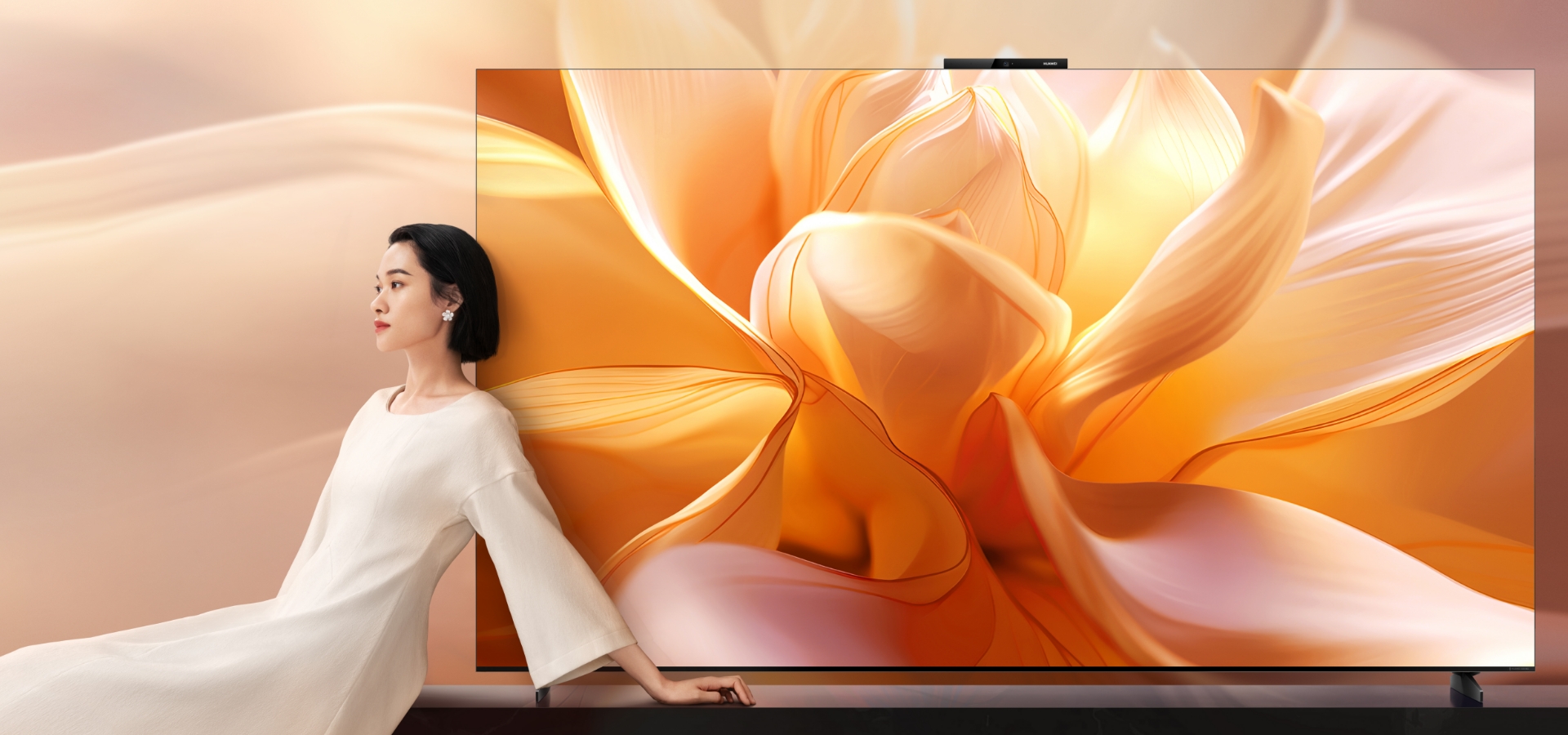 一位女性站在智慧屏旁,华为 Vision 智慧屏 4 Pro 正面特写视图,展示屏幕
