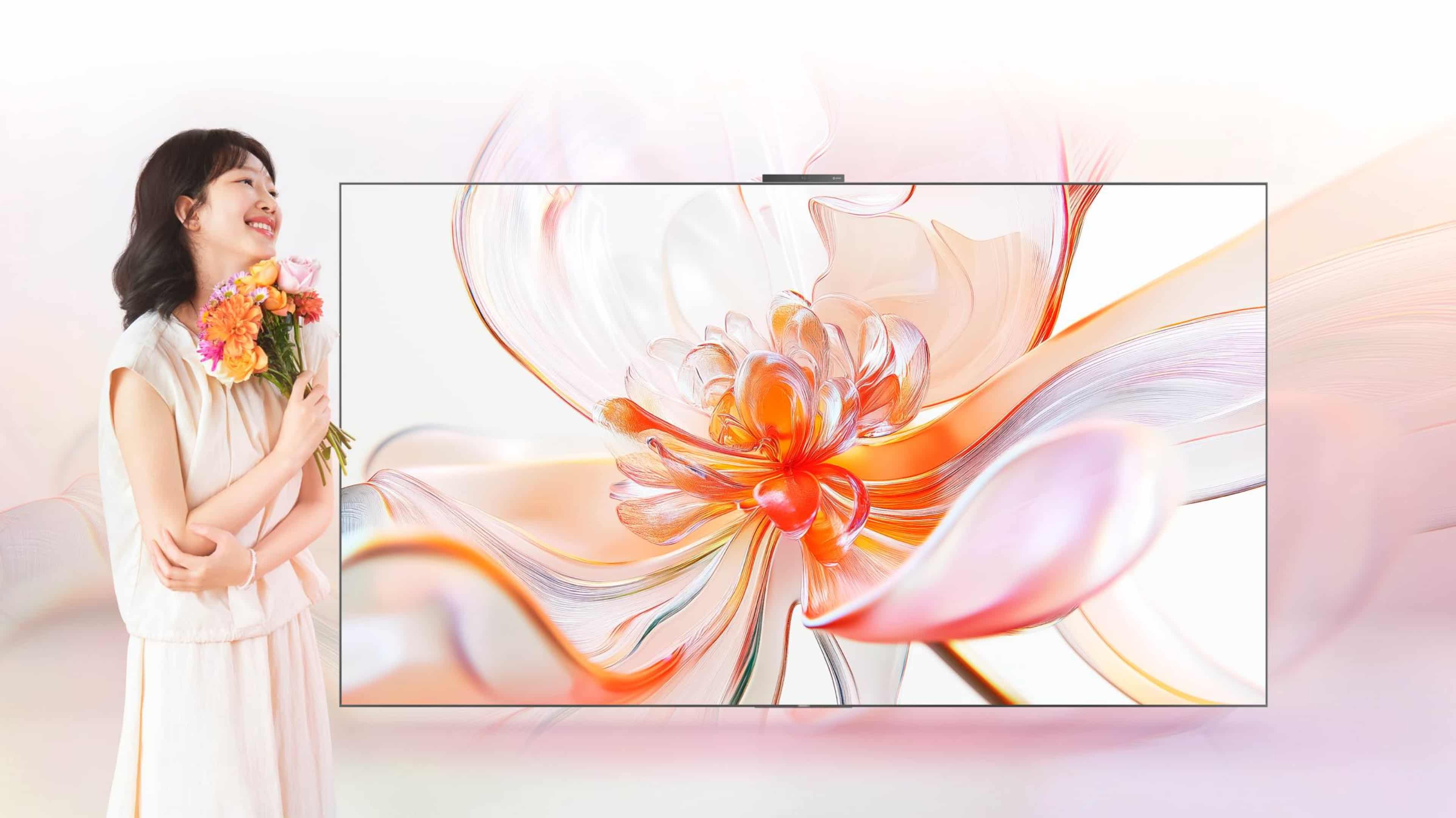 用户手持鲜花站在华为 Vision 智慧屏 5 旁边，展示了智慧屏的纤薄
