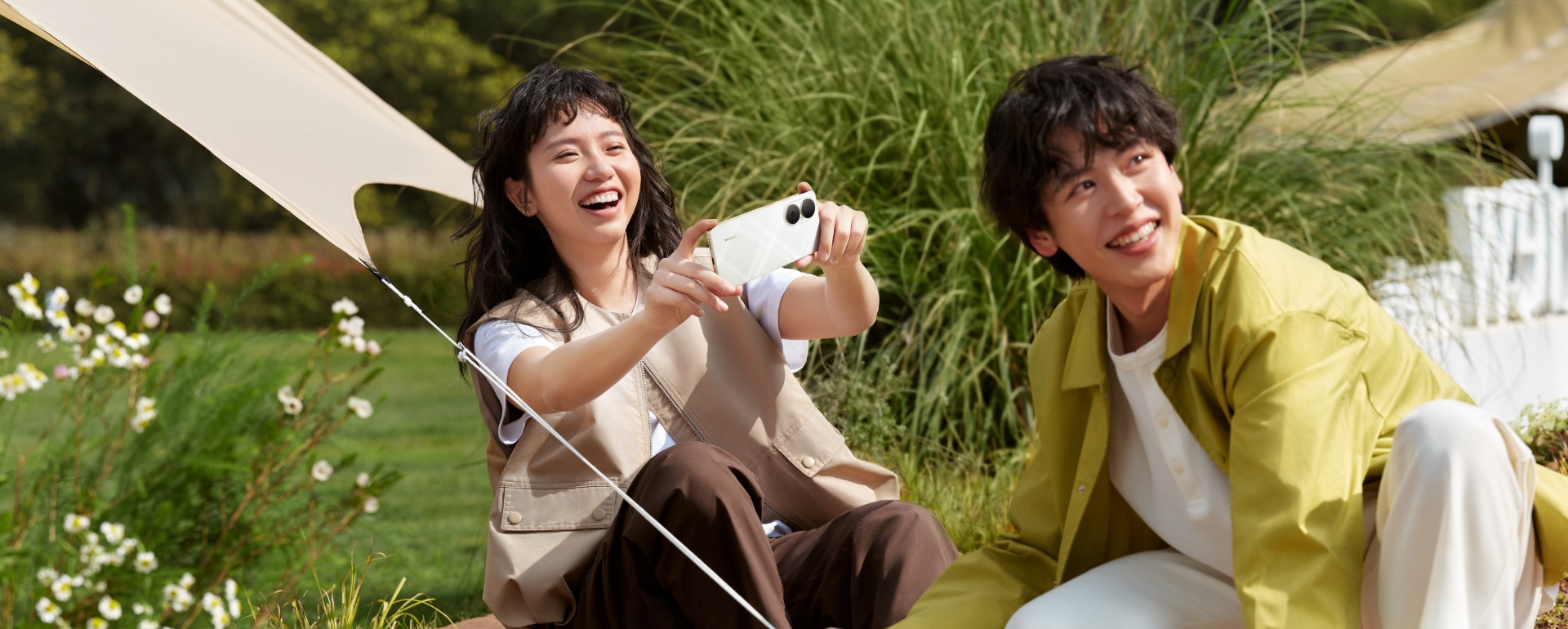 配合在户外野营的场景，展示天际白颜色的华为畅享 80