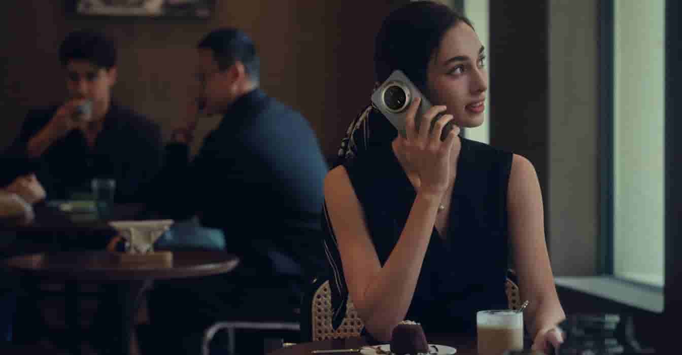 一名女性拿着 HUAWEI Mate 70 Air，躺在床上布置任务