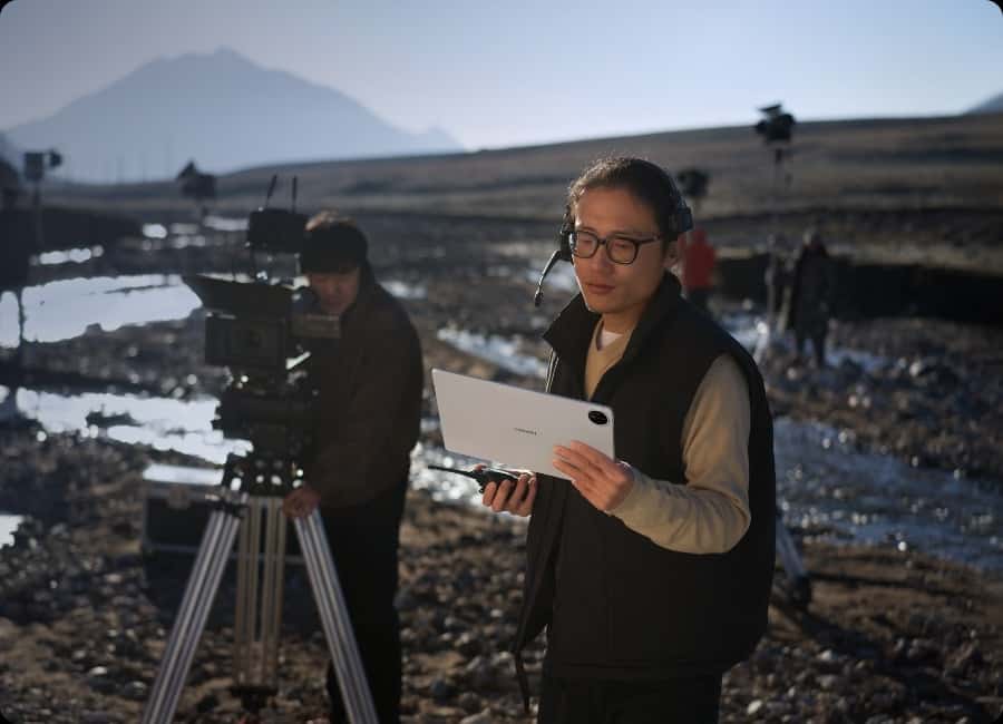 一位导演用 HUAWEI MatePad Pro 13.2 英寸在拍摄现场指导拍摄