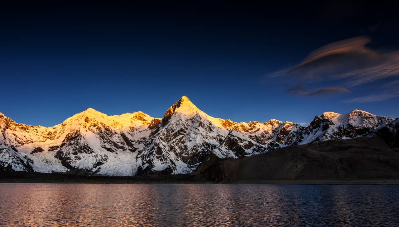 华为智慧屏 S6 屏幕画面，展示雪山景色在日出时段强烈的明暗对比