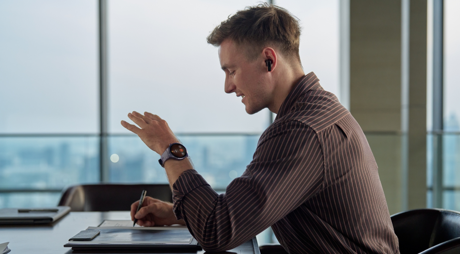 一个佩戴 HUAWEI WATCH 5 的男人会议中，使用手表进行接打电话，展示了独立通话的功能