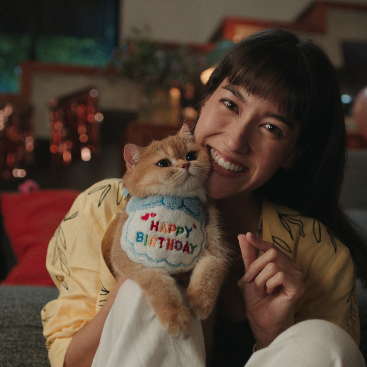 一个佩戴 HUAWEI WATCH 5 的女人，抱着她的宠物猫进行合照，通过手势操控隔空完成拍照