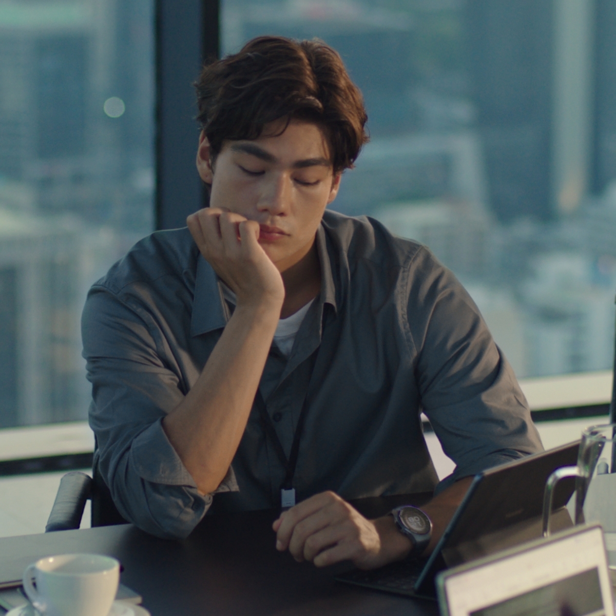 一个佩戴 HUAWEI WATCH 5 的男人，在办公室中通过手势操控展开、查看手表上的关键信息