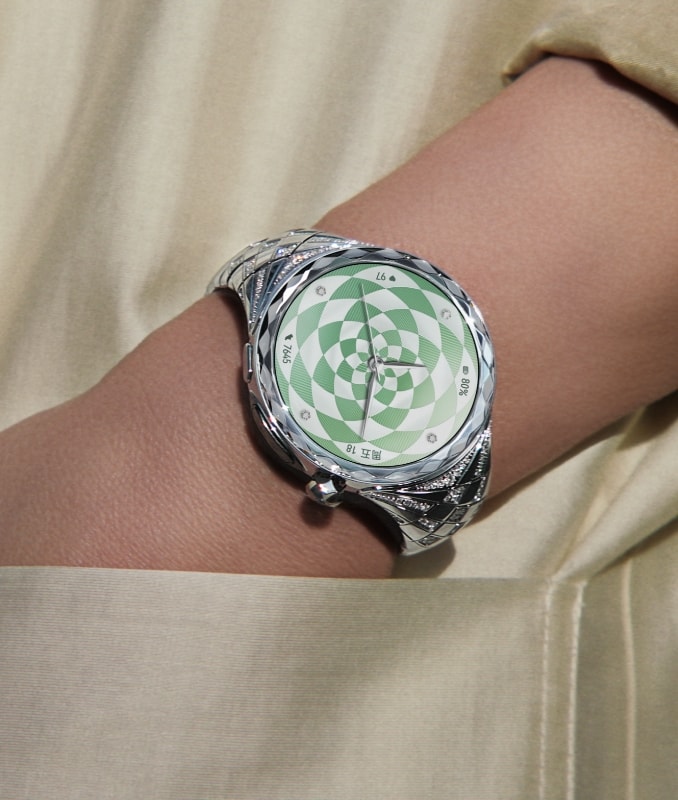 女性用户佩戴 HUAWEI WATCH ULTIMATE DESIGN 非凡大师 星钻绽放款，展示了智能手表的独立通讯、实况窗与独立支付功能