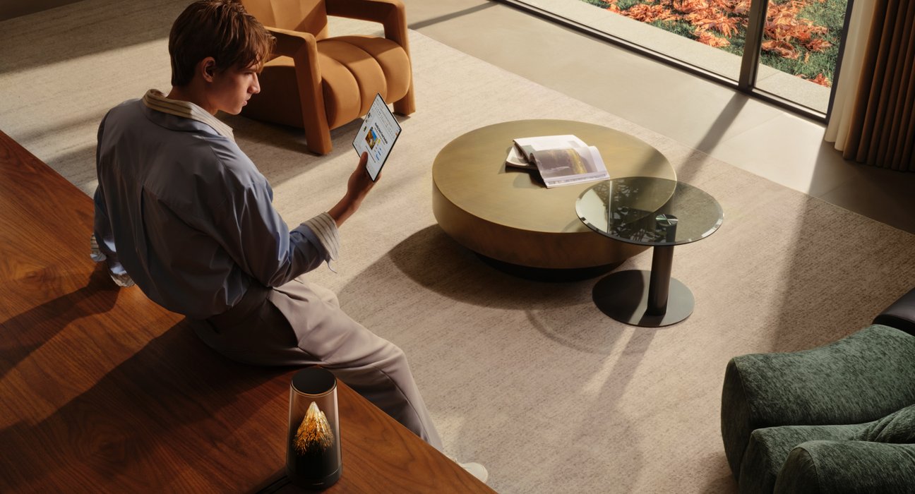 Displays a man holding an electronic device at home, demonstrating the high-speed performance of HUAWEI WiFi Mesh X3 Pro Wi-Fi 7+.