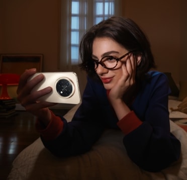 A young woman is watching videos on the HUAWEI nova 15 Max, showing its local video playback lasts up to 27 hours