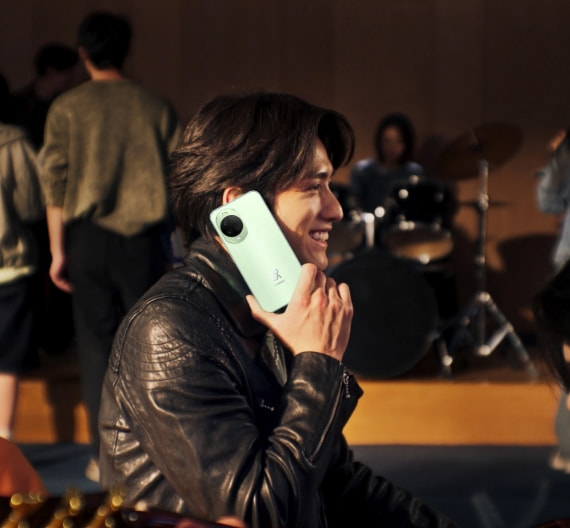 Male model making a phone call in a noisy room, demonstrating AI Call Noise Reduction on HUAWEI nova 15