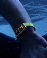 A user wearing green HUAWEI Band 10 is swimming in a pool, with the device displaying swimming-related data on its screen. This highlights the band's AI swimming stroke recognition feature