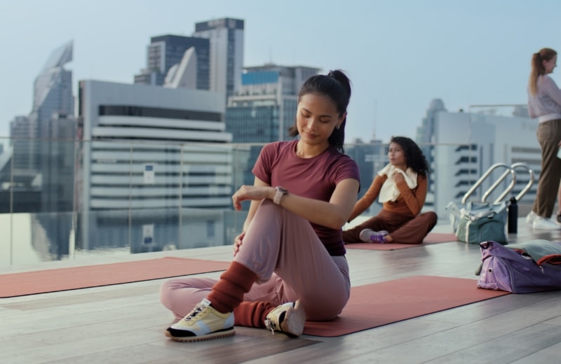 A female user practicing yoga checks the data on her HUAWEI Watch, showcasing PCOS risk research capabilities of HUAWEI Research
